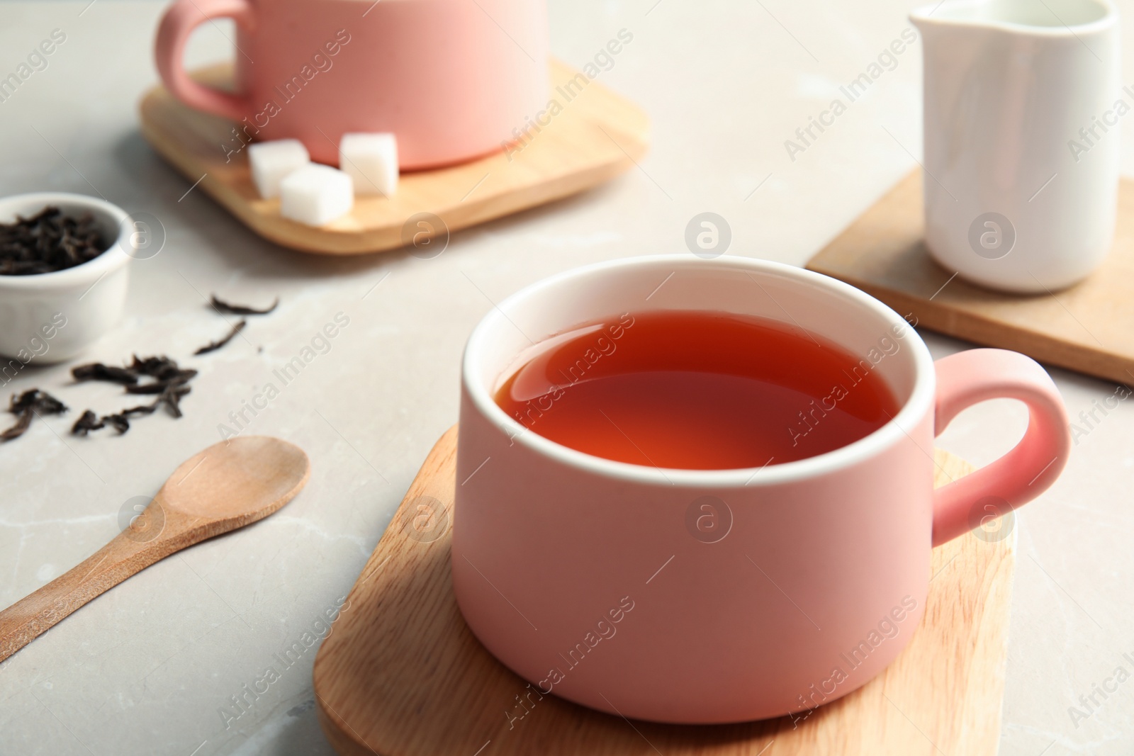 Photo of Cup of black tea on table, closeup