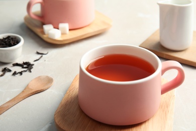 Photo of Cup of black tea on table, closeup