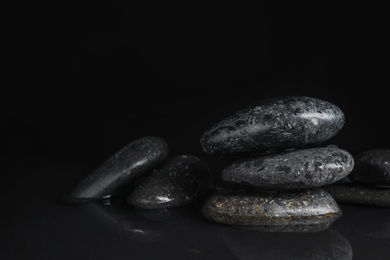Photo of Stones in water on black background, space for text. Zen lifestyle