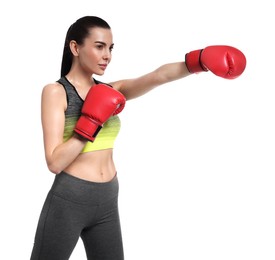 Beautiful woman in boxing gloves training on white background