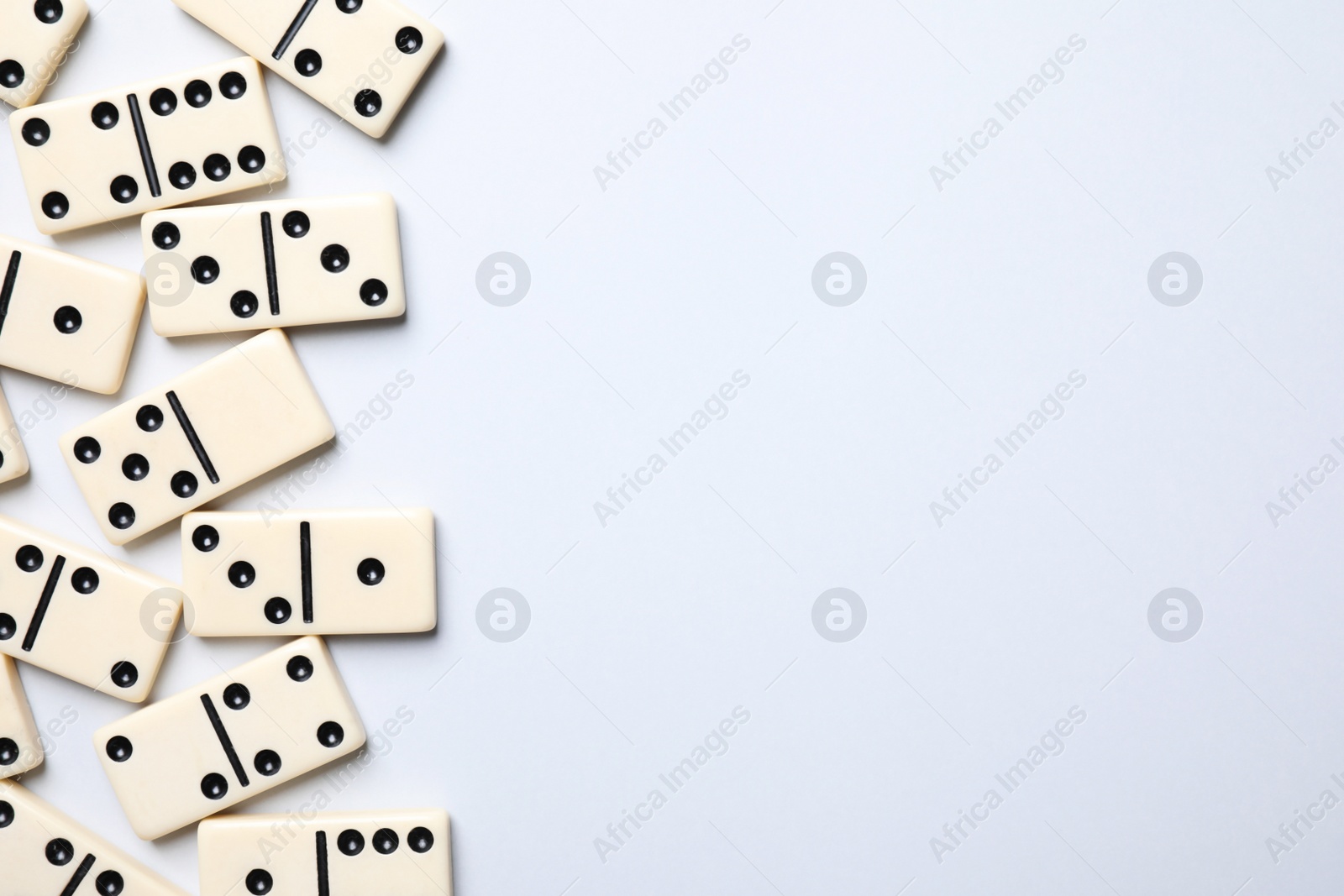 Photo of Classic domino tiles on white background, flat lay. Space for text