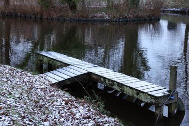 Wooden pier near water canal on winter day