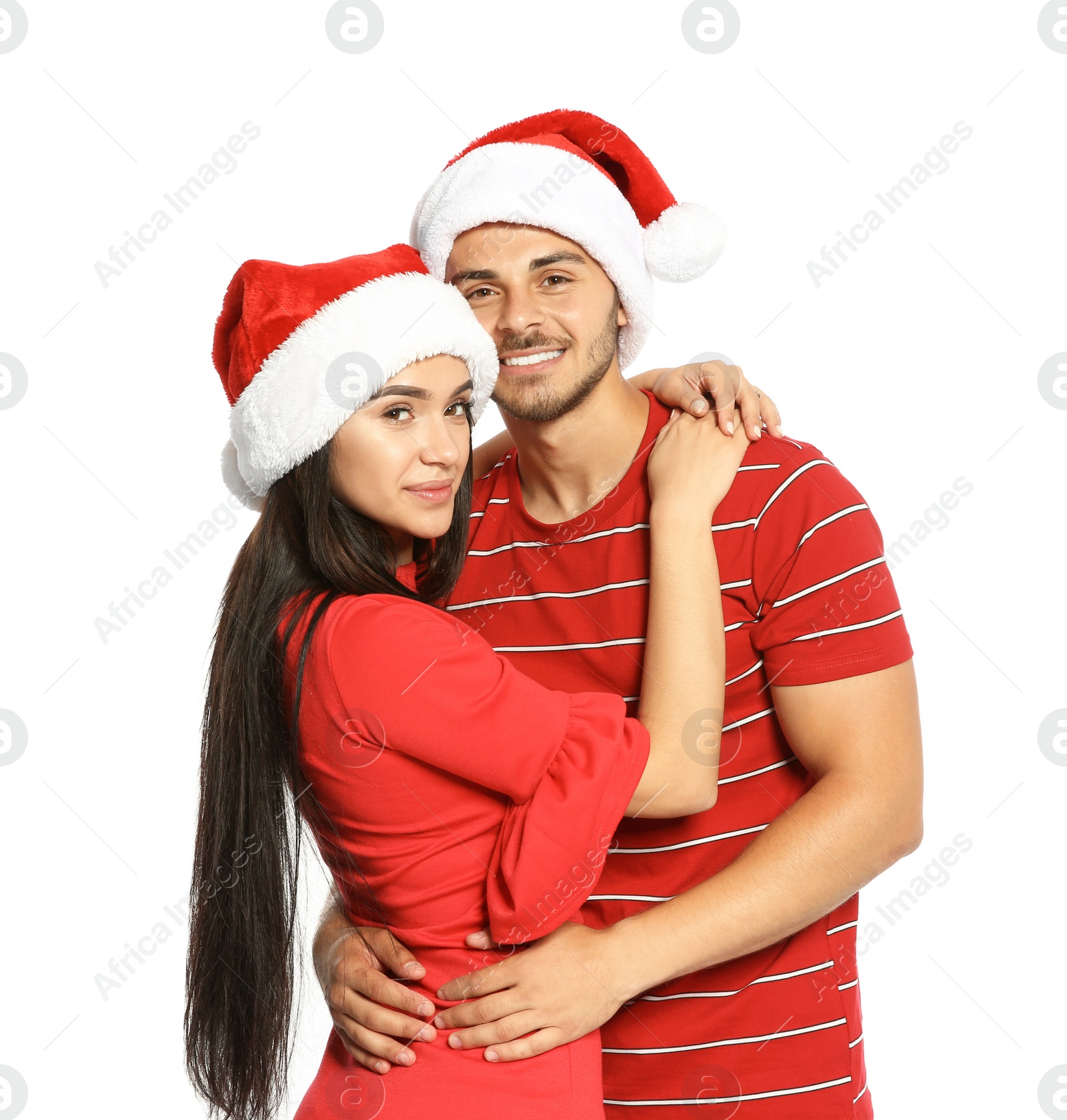 Photo of Young happy couple with Santa hats on white background. Christmas celebration