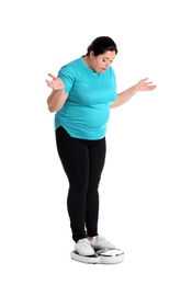 Photo of Overweight woman in sportswear using scales on white background