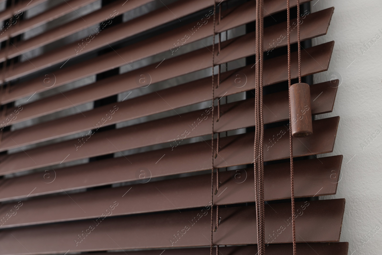 Photo of Stylish horizontal window blinds on white wall, closeup