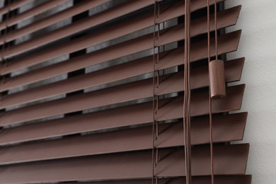 Photo of Stylish horizontal window blinds on white wall, closeup