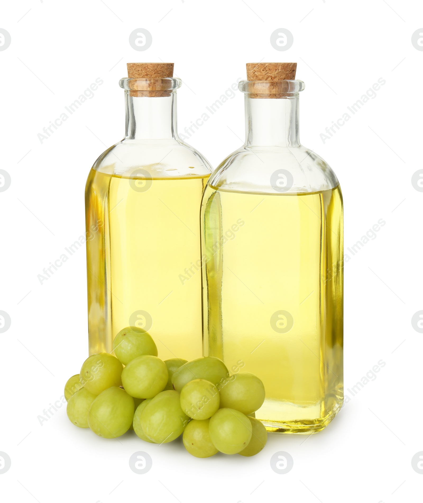 Photo of Vegetable fats. Bottles of cooking oils and fresh grapes isolated on white