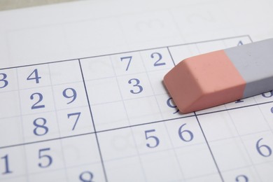 Photo of Sudoku puzzle grid and eraser, closeup view