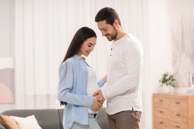 Happy pregnant woman with her husband at home