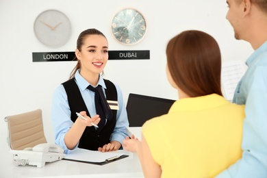 Photo of Female receptionist working with clients in hotel