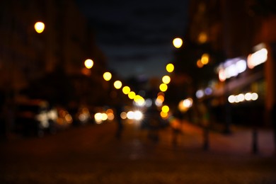 Photo of Blurred view of city street with lights at night. Bokeh effect