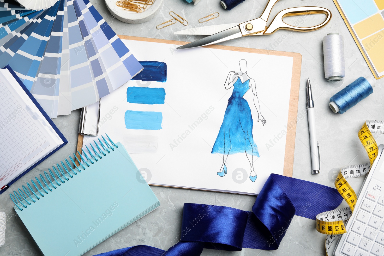 Photo of Flat lay composition with drawing of dress on light grey marble table. Designer's workplace