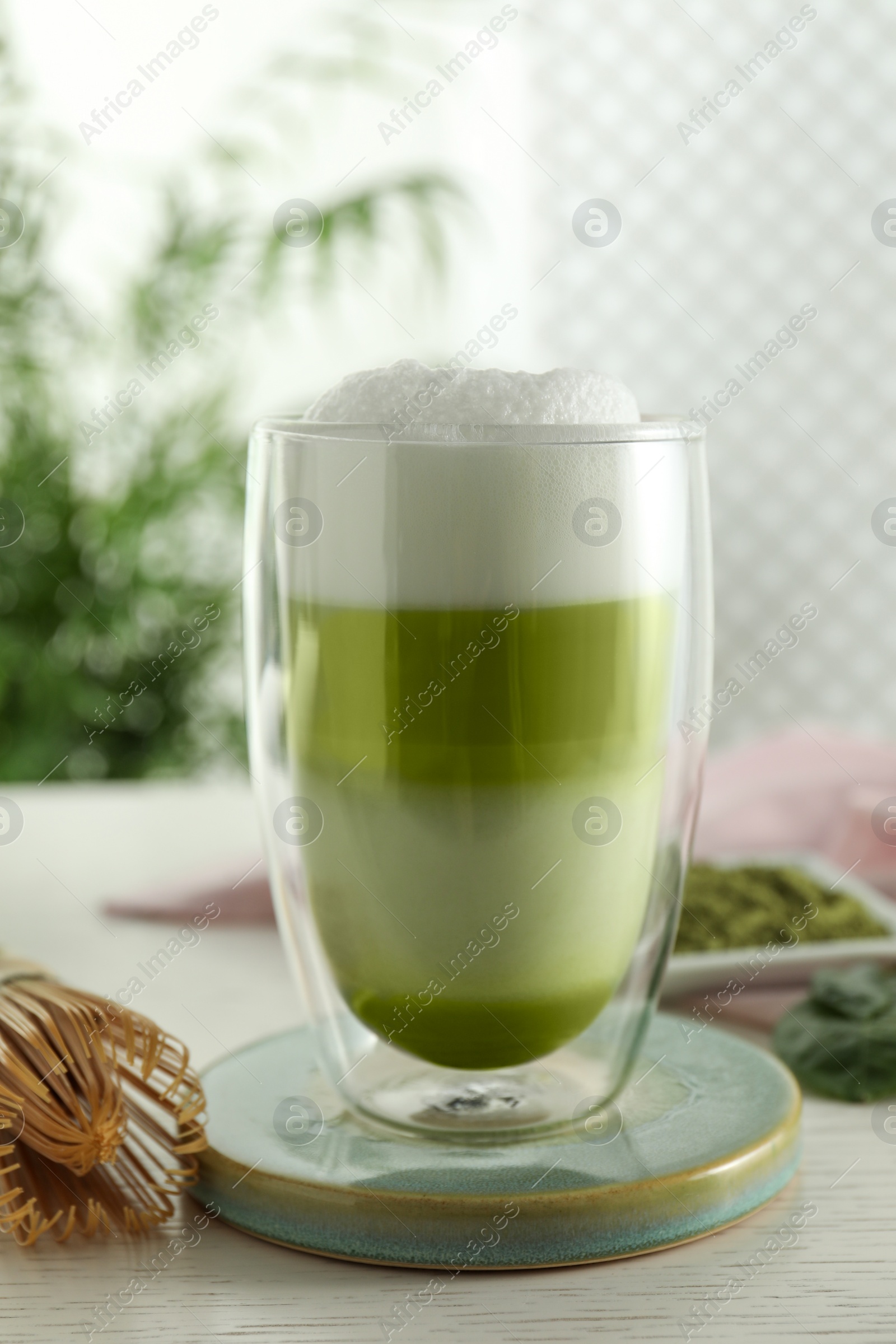 Photo of Glass of tasty matcha latte on light grey table