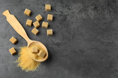 Photo of Spoon with brown sugar cubes on grey table, flat lay. Space for text