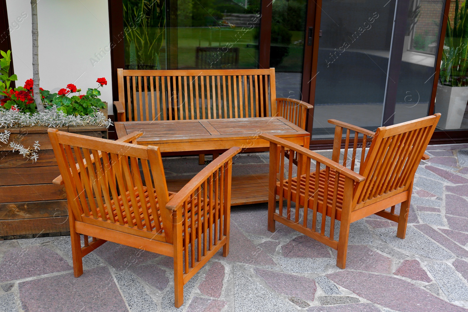 Photo of Wooden garden furniture on backyard near modern house