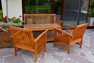 Photo of Wooden garden furniture on backyard near modern house