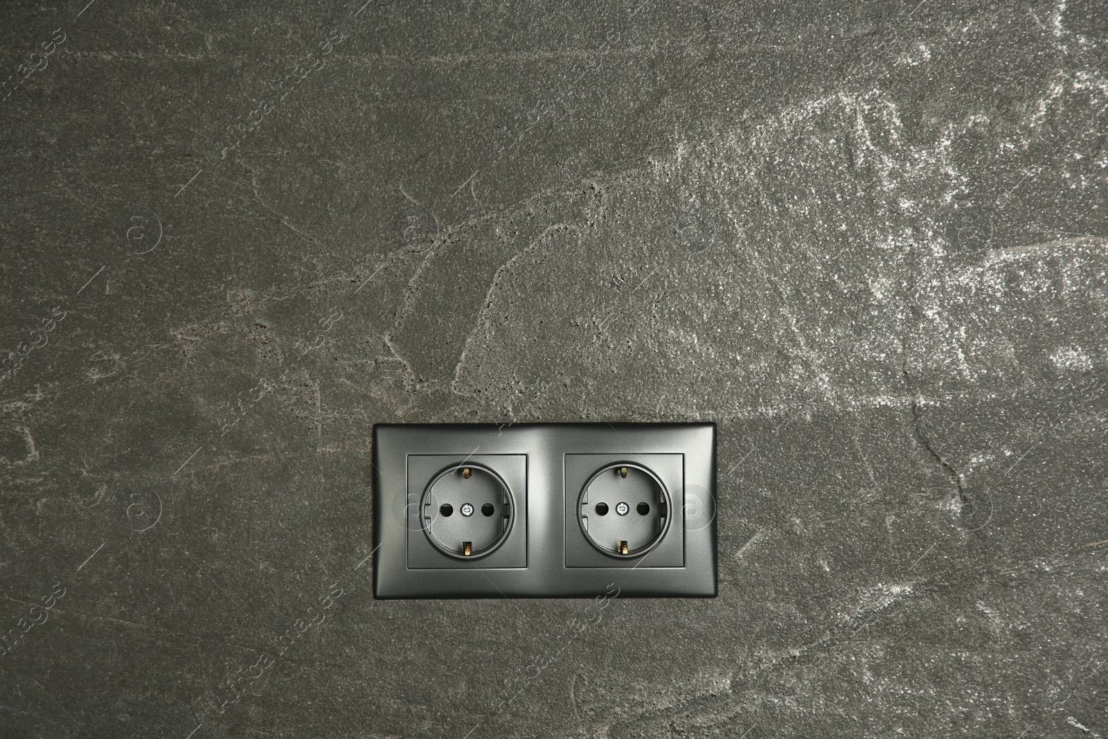 Photo of Power sockets on dark grey wall, space for text. Electrical supply