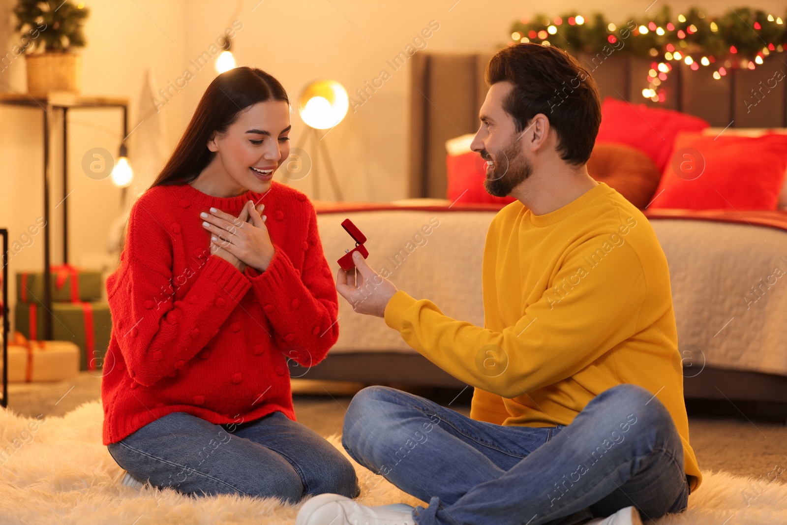 Photo of Man with engagement ring making proposal to his girlfriend at home on Christmas