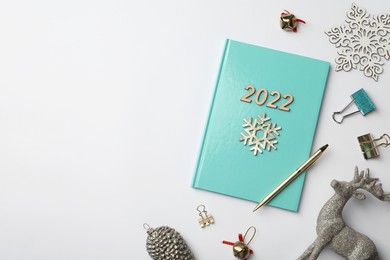 Photo of Stylish planner and Christmas decor on white background, flat lay with space for text. 2022 New Year aims