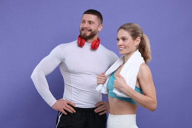 Photo of Athletic people with headphones and towel on purple background