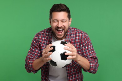 Emotional sports fan with ball on green background