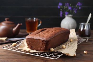 Delicious chocolate sponge cake and nuts on wooden table