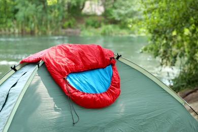 Sleeping bag on camping tent near lake
