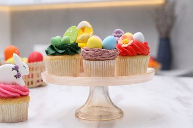 Photo of Tasty decorated Easter cupcakes on white marble table