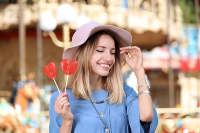 Beautiful woman with candies having fun at amusement park