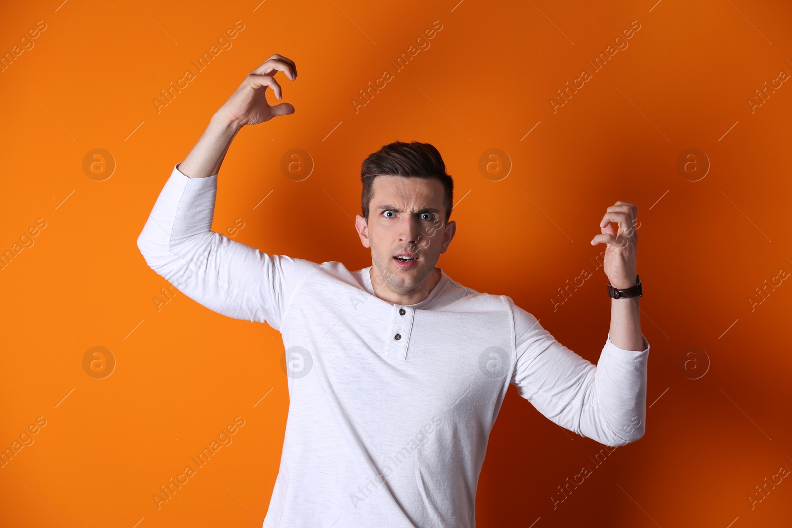 Photo of Handsome emotional young man on color background