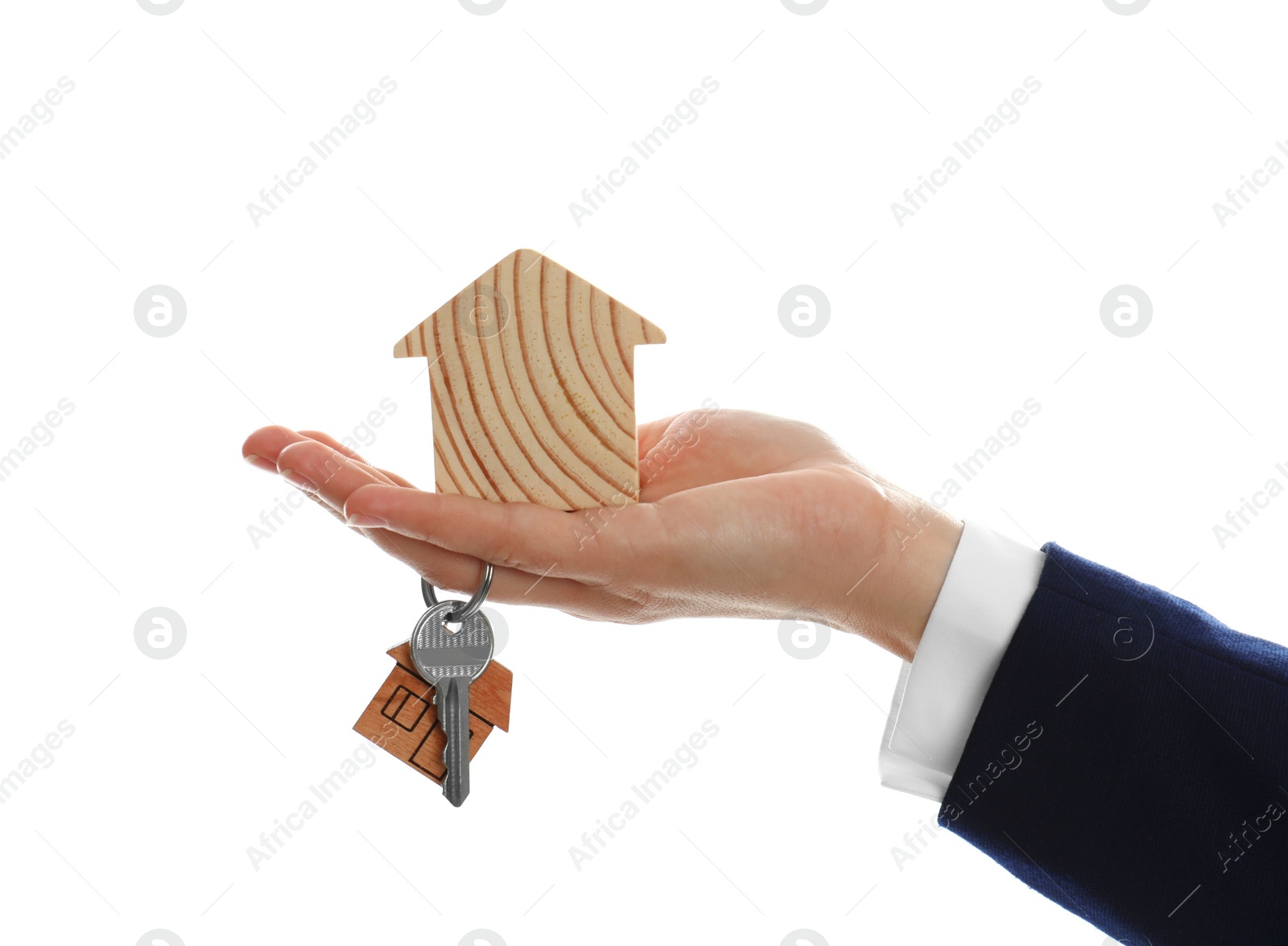 Photo of Real estate agent holding house figure and key on white background, closeup