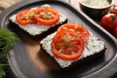 Photo of Delicious ricotta bruschettas with sliced tomatoes and dill on wooden table, closeup