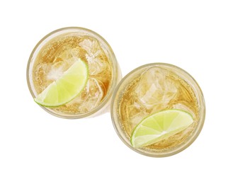 Photo of Glasses of tasty ginger ale with ice cubes and lime slices isolated on white, top view