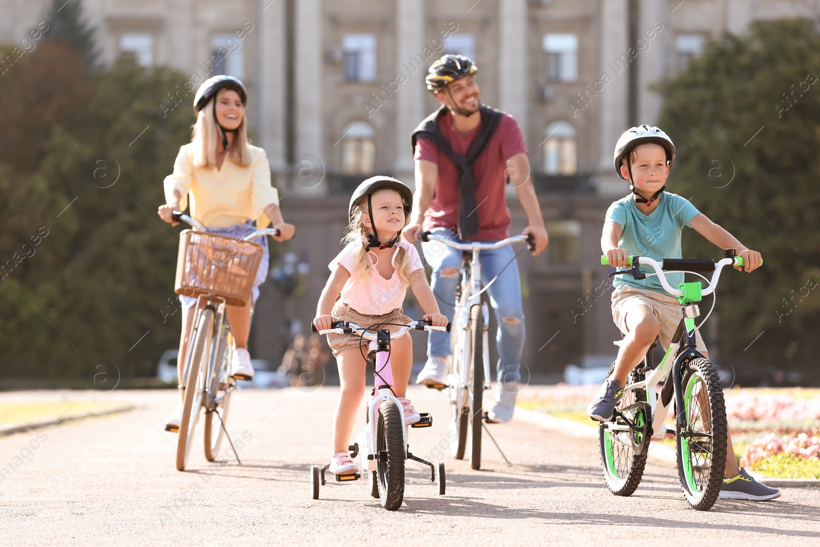 Photo of Happy family riding bicycles outdoors on summer day