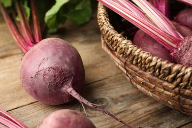 Photo of Raw ripe beets on wooden table, closeup