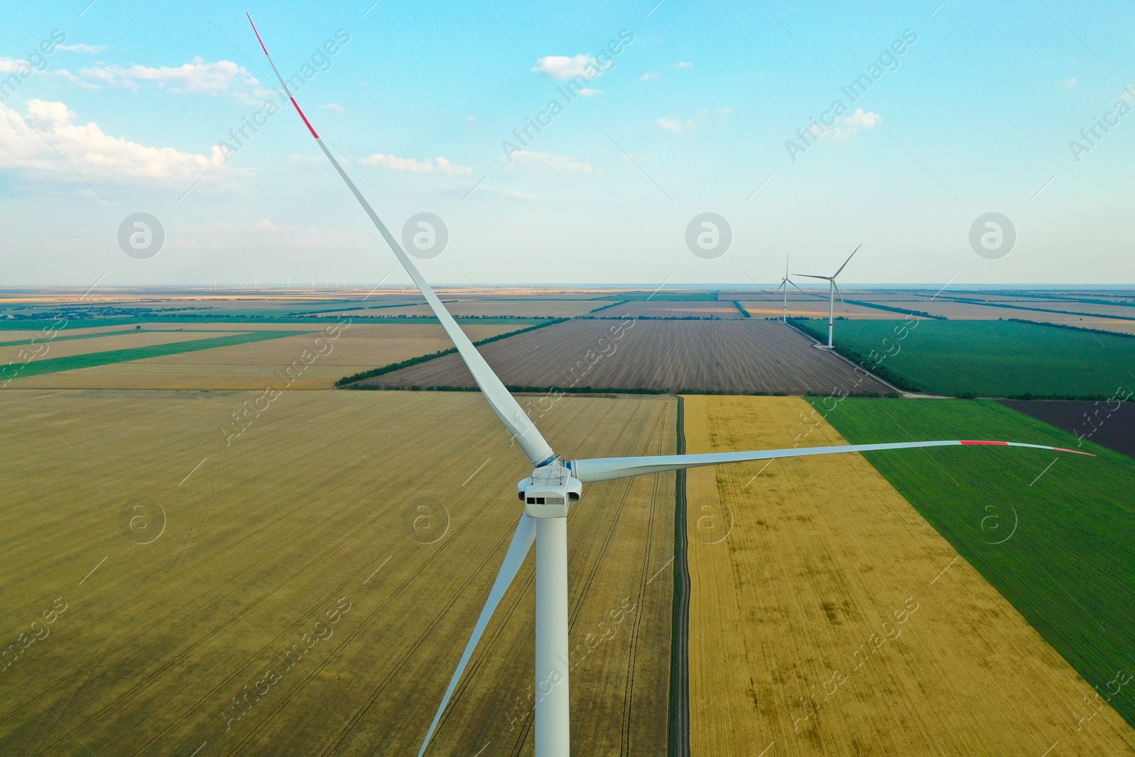 Photo of Modern windmill in wide field. Energy efficiency