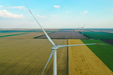 Photo of Modern windmill in wide field. Energy efficiency