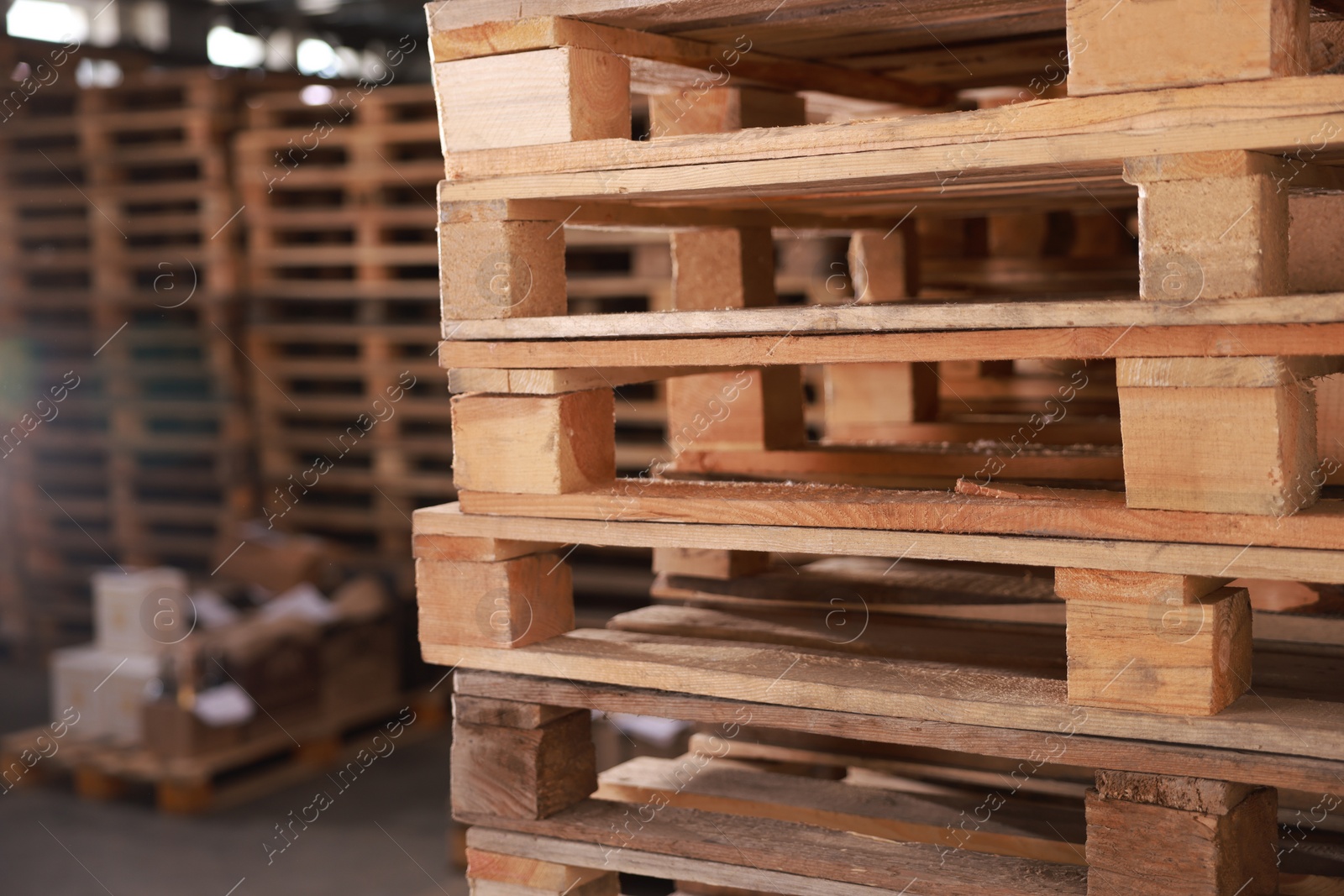 Image of Many empty wooden pallets stacked in warehouse, closeup