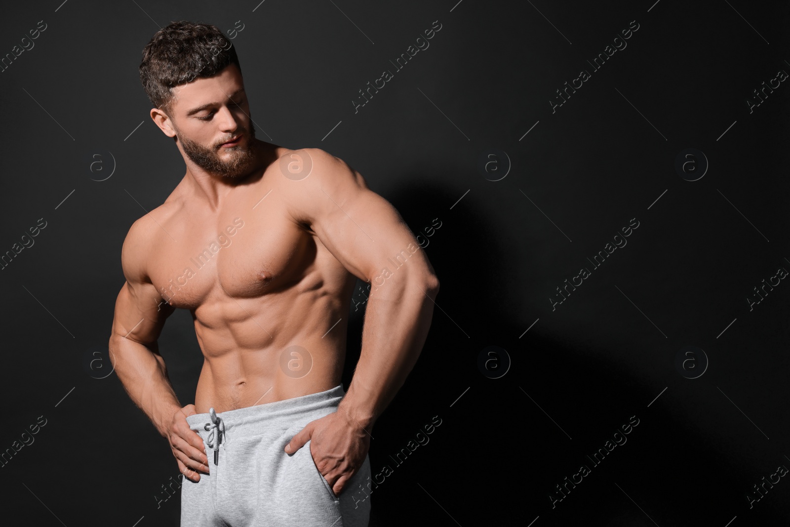 Photo of Handsome muscular man on black background, space for text. Sexy body