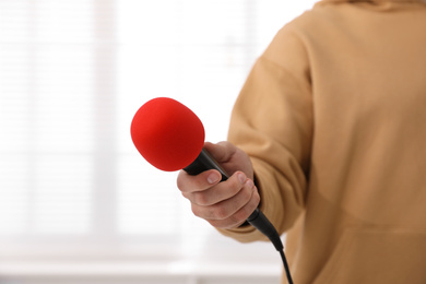 Photo of Professional journalist with microphone in room, closeup