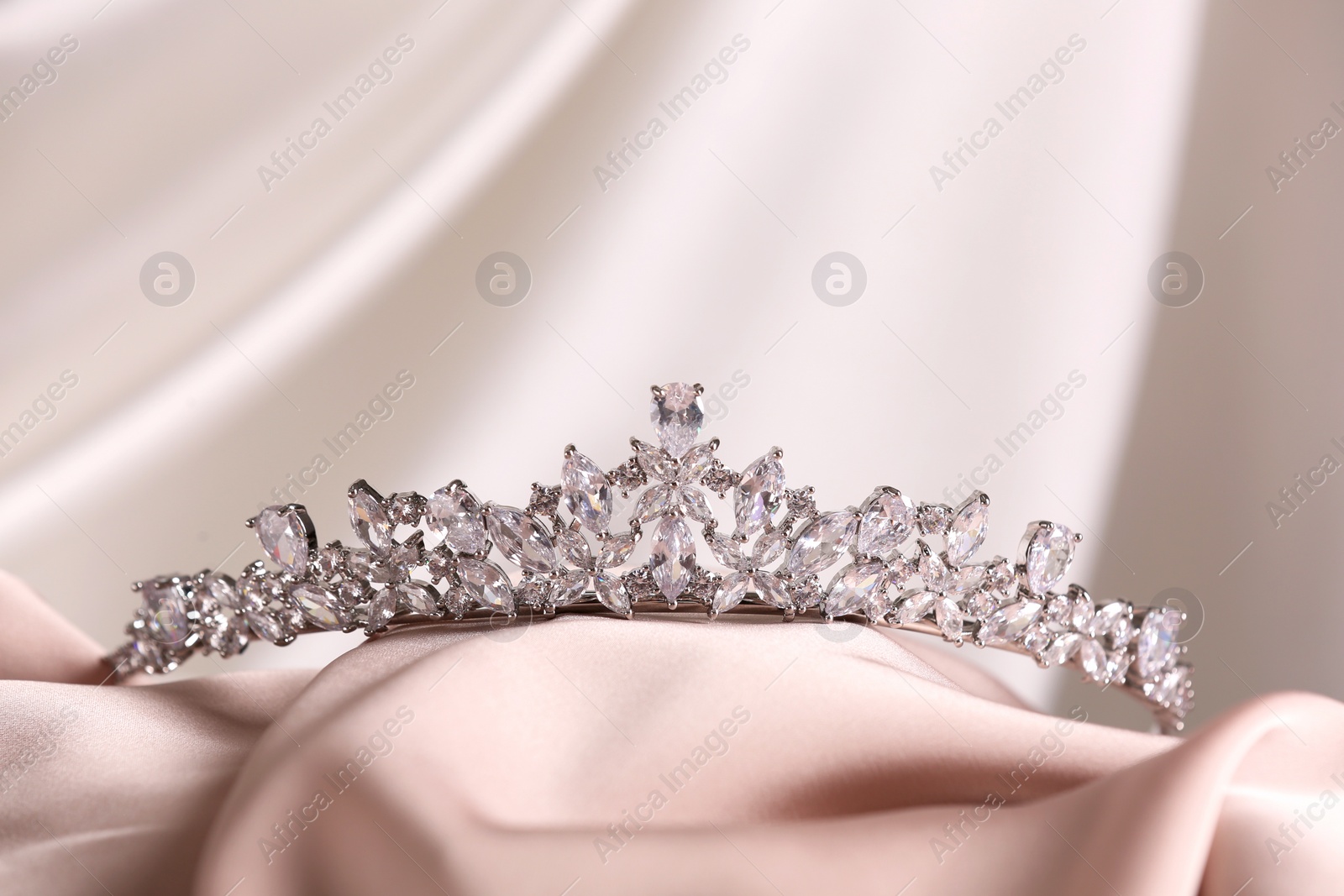 Photo of Beautiful silver tiara with diamonds on light cloth