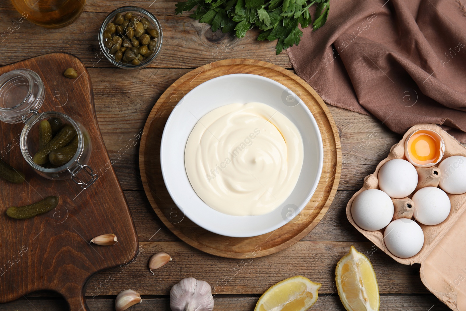 Photo of Flat lay composition with ingredients for tartar sauce on wooden table