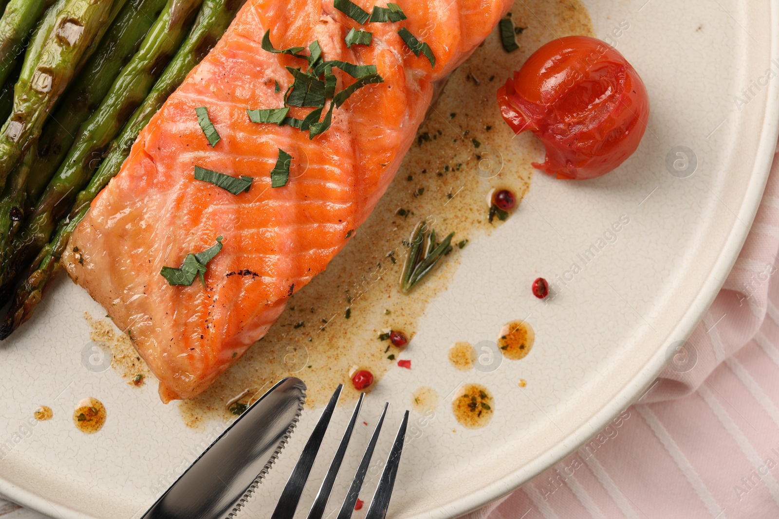 Photo of Tasty grilled salmon with tomato, asparagus and spices served on table, top view