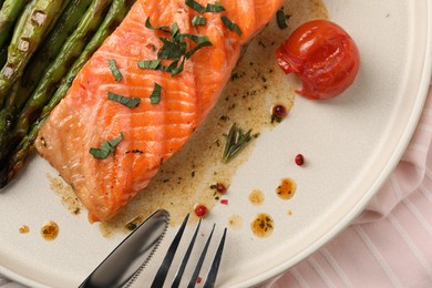 Photo of Tasty grilled salmon with tomato, asparagus and spices served on table, top view