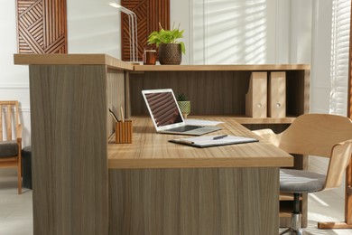 Photo of Receptionist's workplace with laptop in hotel. Interior design