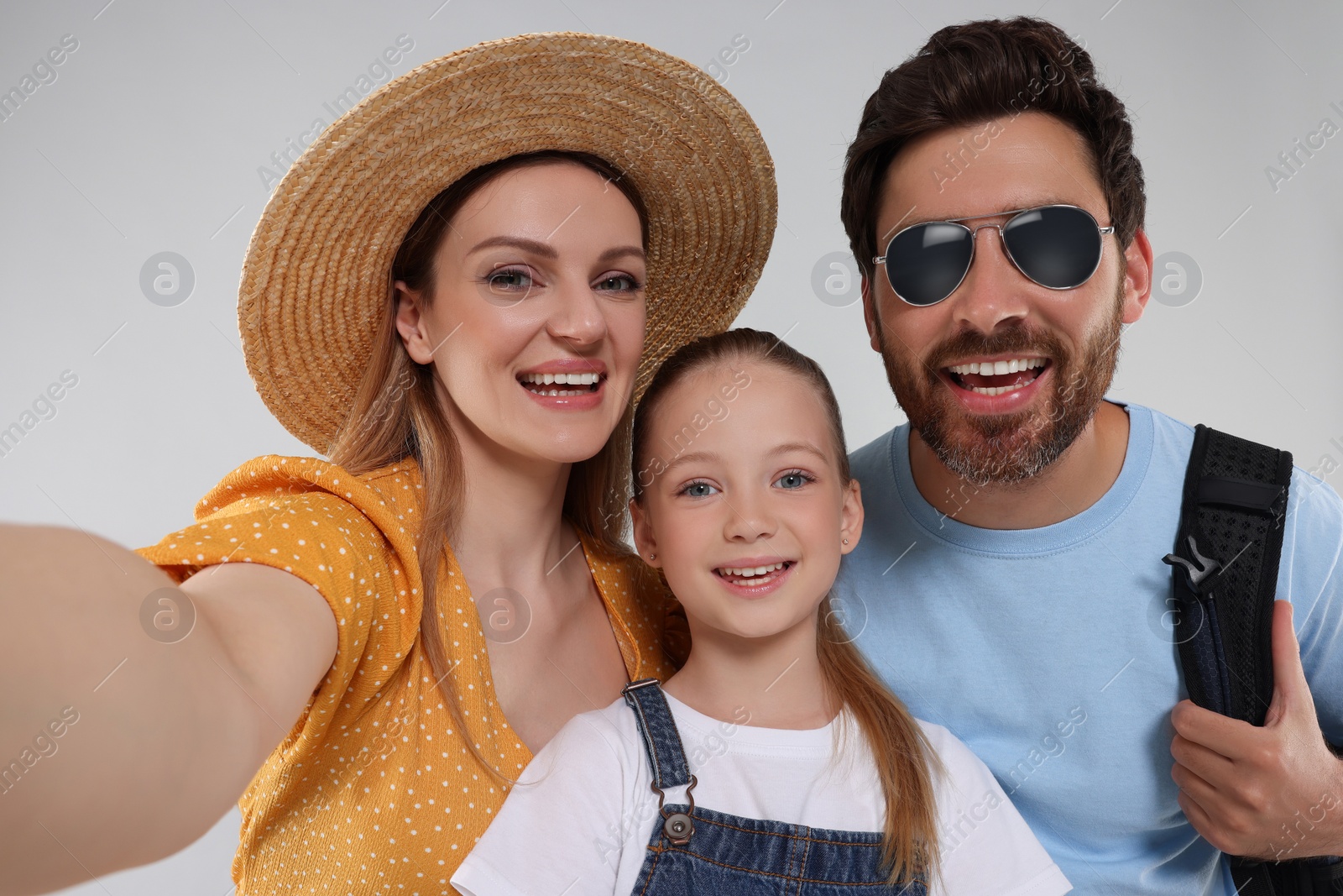 Photo of Happy family taking selfie on light grey background