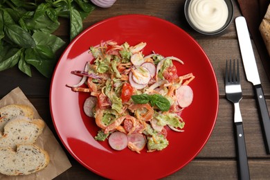 Photo of Delicious salad with mayonnaise served on wooden table, flat lay