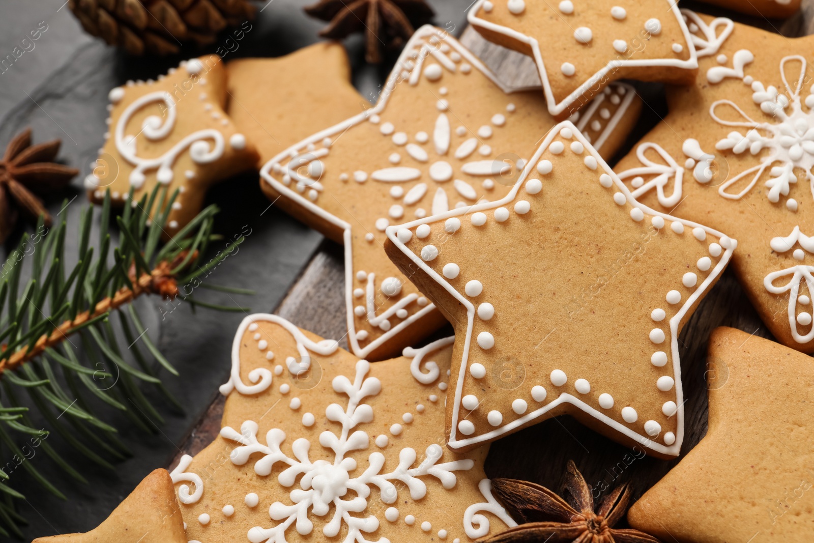 Photo of Tasty Christmas cookies, fir branch and anise on black table, closeup