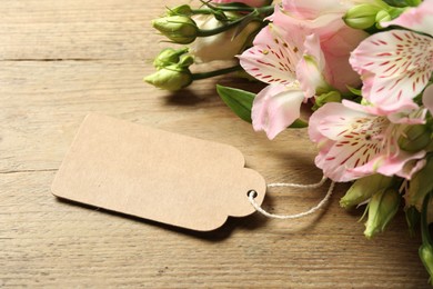 Happy Mother's Day. Beautiful flowers with blank card on wooden table, closeup