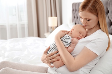 Photo of Mother with her sleeping baby in bedroom